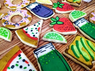 Cute sugar cookies decorated to look like strawberries, limes, avocado toast, drinks and pizza slices
