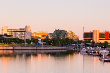 View of the Louise Basin with moored sailboats and buildings in the background during a golden hour dawn in the lower town, Quebec City, Quebec, Canada