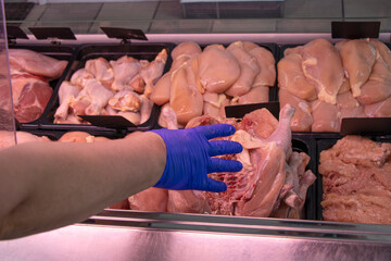 Meat shop. Close-up. A hen. Seller hands is holding meat. Hygiene. Raw.