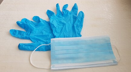 protective gloves and facial mask on white background