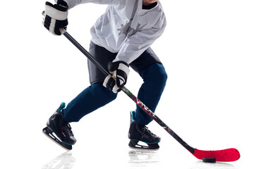 Fototapeta premium Unrecognizable male hockey player with the stick on ice court and white background. Sportsman wearing equipment and helmet practicing. Concept of sport, healthy lifestyle, motion, action. Close up.