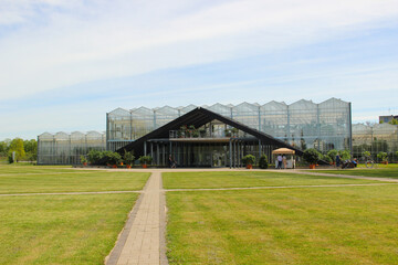 Fototapeta na wymiar Botanic garden with glass orangery. A path leads to a tropical house.