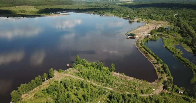 Aerial view of ship floating the river Kama, Perm krai, Russia. Motorboat and rural landscape from above, water waves, trees on the bank, summer sun day. Boat sailing on river. Top view.
