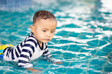 Little adorable boy in swimming suit enjoying swimming  in the pool