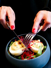 Delicious fresh boiled egg with fresh lettuce and beetroot in grey ceramic bowl for starter.