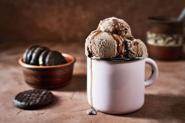 Chocolate ice cream balls with chocolate topping in a metal mug