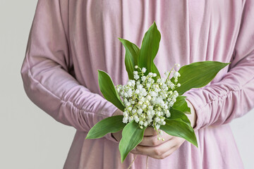 woman holding lily of the valley flower bouquet 