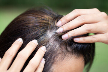 Naklejka premium Young woman shows her gray hair roots