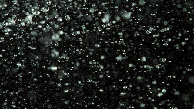 Super slow motion of lime pieces collision with water splashes, black background. Filmed on high speed cinema camera, 1000 fps.