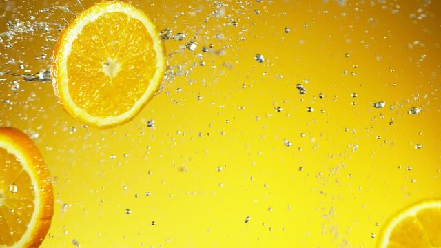 Super slow motion of orange slices collision with water splashes. Filmed on high speed cinema camera, 1000 fps.