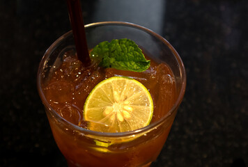 Lemon and spearmint in ice tea with dark background.