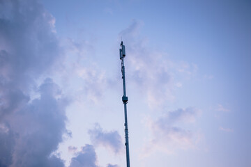 Mobile communications tower on the sunset sky background. 