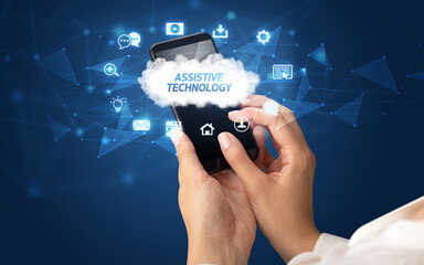 Female hand holding smartphone with ASSISTIVE TECHNOLOGY inscription, cloud technology concept