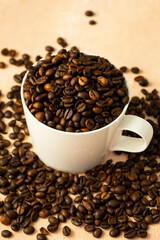 selective focus, roasted coffee beans with a slide in a white ceramic mug, on a light pink background