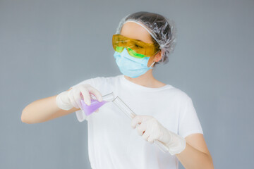 Portrait of laboratory assistant nurse woman wearing medicine protective glasses, face medical mask during flu covid-19 epidemic. Holding vaccine on gray background.