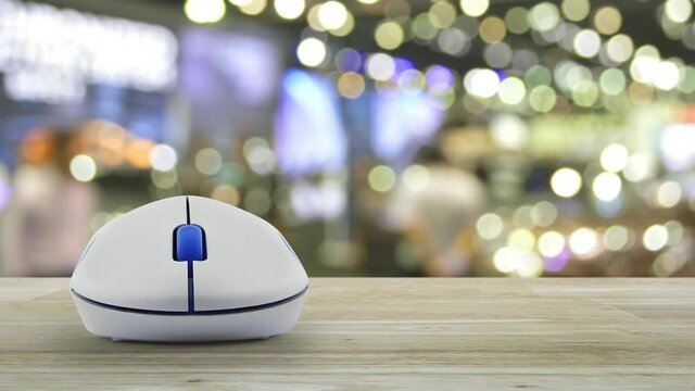 Download flat icon with wireless computer mouse on wooden table over blur light and shadow of shopping mall, Technology internet online concept