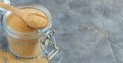 Jar of raw Amaranth seeds with a spoon