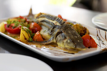 Grilled fish. Cooked fish is on the table .Grilled sturgeon fish. Grilled sturgeon fish. Sturgeon baked with vegetables. Healthy food. Soft selective focus