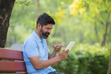 Fototapeta premium Man using mobile phone in park