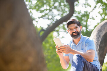 Fototapeta premium Man using mobile phone in park