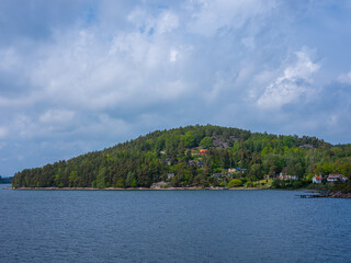 Obraz premium Forest slope landscape with houses by the ocean in Sweden