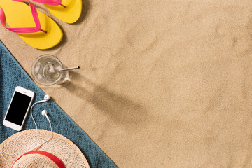Fototapeta na wymiar Summer vacation composition. Flip flops, hat and glass of water on sand background. Travel vacation concept. Summer background. Border composition made of towel