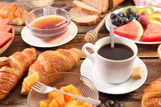 delicious full breakfast with coffee cup, tea cup, croissant and fresh fruits