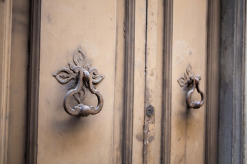 Antique metal handle on front door. Vintage door handles in painted metal. Close up shot.