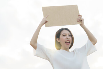Woman holding a blank banner to put the text at protesting.