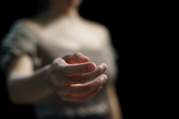 Woman open empty hand on black background.