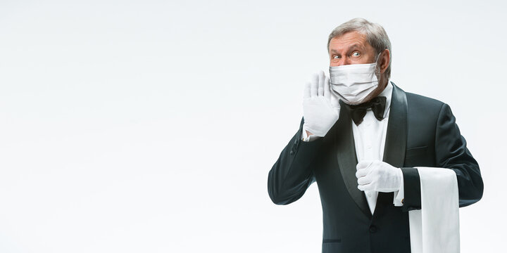 Healthcare. Elegance senior man waiter in protective face mask on white background. Flyer with copyspace. Cafe, restaurant opening. Safety during coronavirus pandemic. Taking care of guests, clients.
