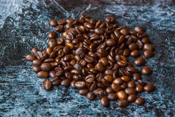 Obraz premium A handful of coffee roasted beans on an abstract background.