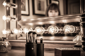 vintage vanity makeup accessories, makeup dressing table with undefined woman at mirror