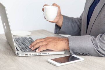 business man is using laptop in coffee shop sitting at a table