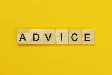 Advice word of wooden letters on a yellow background