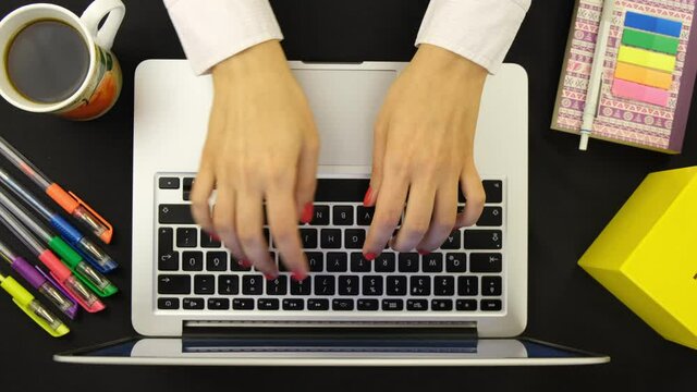 Female hands typing on keyboard shot from top view closeup 4K. Desktop view of business woman working using laptop. Using track pad working productive.
