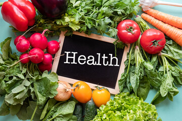 Fresh vegetables around black desk with text "Health"on blue background