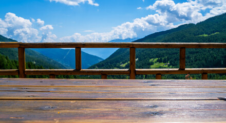Empty wooden rural table space platform and blurred background of nature mountain landscape background with sunny day. For product presentation display montage. Travel and holidays.