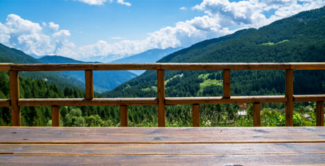 Empty wooden rural table space platform and blurred background of nature mountain landscape background with sunny day. For product presentation display montage. Travel and holidays.