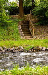 Kamienne schody nad rzeka. Zejscie do wody. Drewniane balustrady. Kamienn brzeg. Tereny rekreacyjne w miescie.