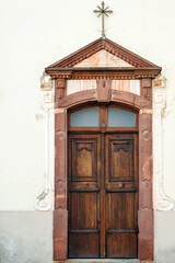Obraz premium Wooden door of an old church. Vintage architecture of the rear entrance. Old church in a town.