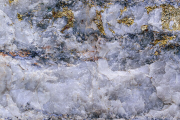 Streaks and inclusions of molybdenum ore in granite stone. Massive sulfide ore. Glitter of steel and gold. Minerals - molybdenite, pyrite, chalcopyrite, white quartz. Concept of mining useful metal.