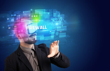 Businessman looking through Virtual Reality glasses with FIREWALL inscription, innovative security concept