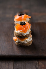 Smoked salmon with creamy cottage cheese and black caviar. Catering finger food, snack, mini canapes.
