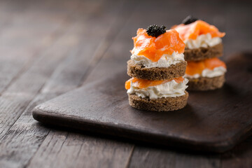 Smoked salmon with creamy cottage cheese and black caviar. Catering finger food, snack, mini...