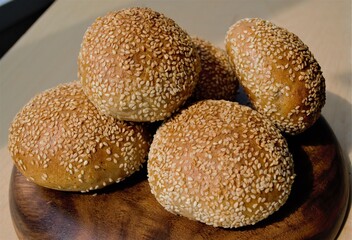 Rye homemade buns with sesame seeds on a flat wooden plate