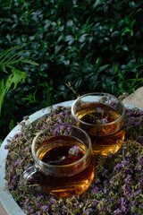 Thyme tea in glass cups among herbs 3