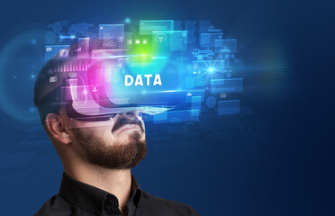 Businessman looking through Virtual Reality glasses with DATA inscription, innovative security concept