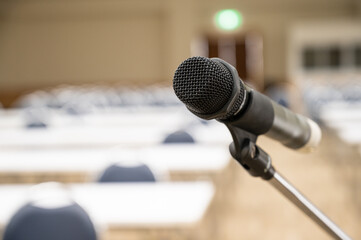 Selective focus microphone in conference hall or meeting room and blurry attendee for seminar business event.