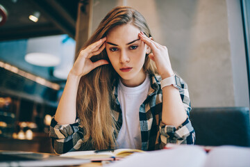 Portrait of tired female student looking at camera and feeling exhausted during exam